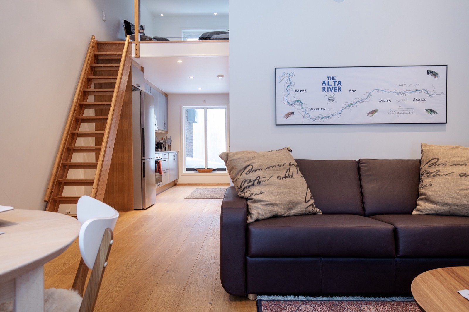 The apartment living room with a sofa and a stair to the loft