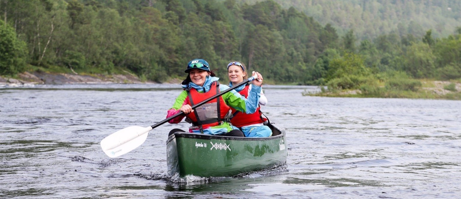 Two paddlers in a green canoe on the Alta River